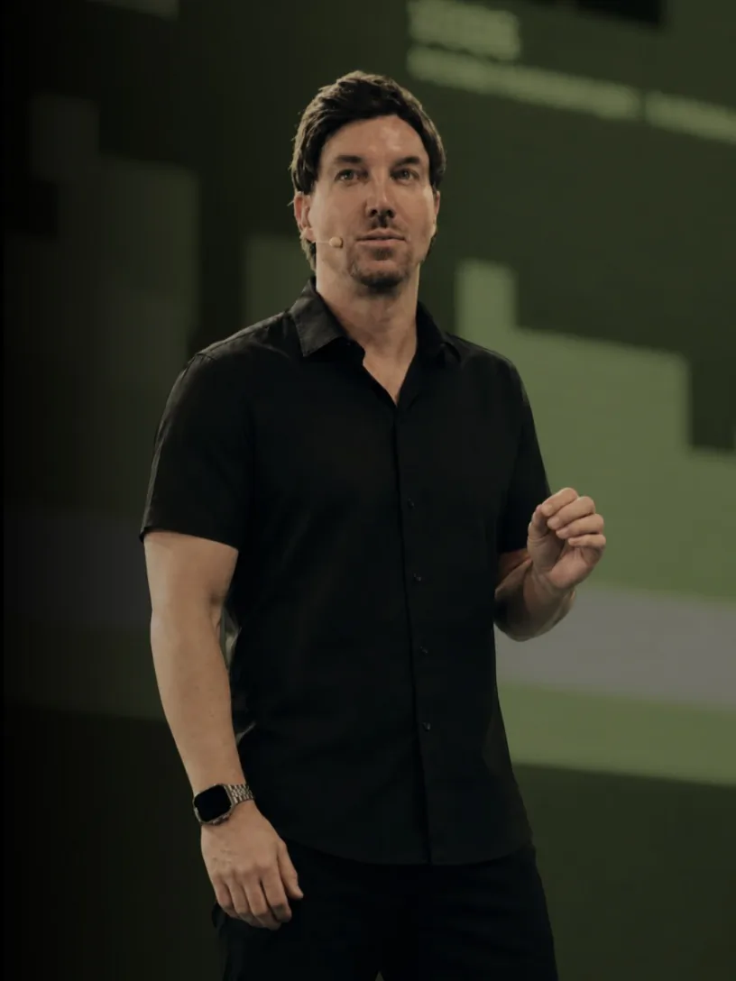 Jan Froboese bei einer KI-Keynote vor grüner Bühnengrafik